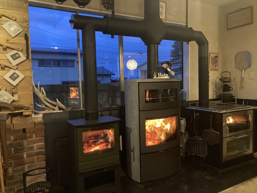 ショールーム内で同時に火の入った3台の薪ストーブとクッキングストーブ