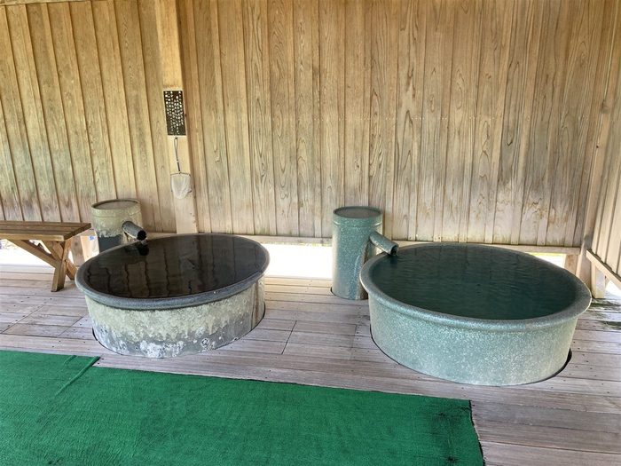 木造あずまやの下に並ぶ金属製の丸桶水風呂