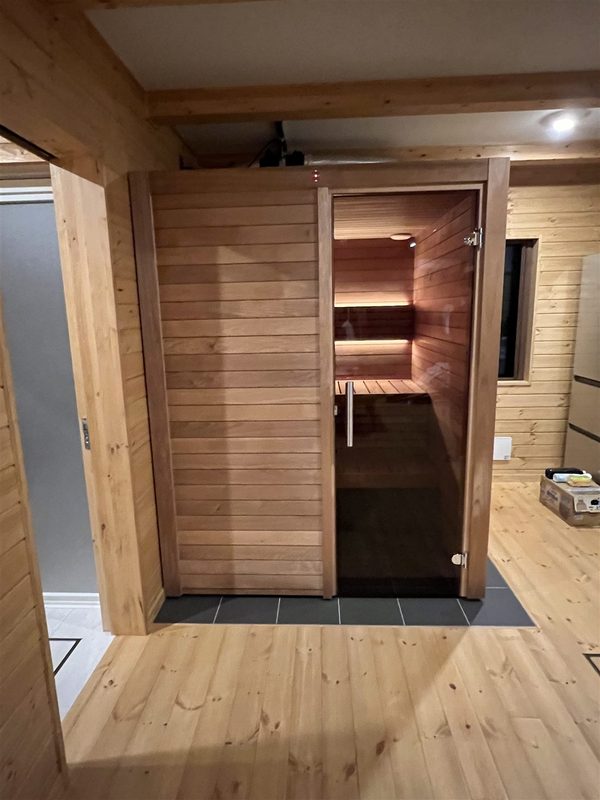 住宅内に設置した木製サウナ室のガラスドア