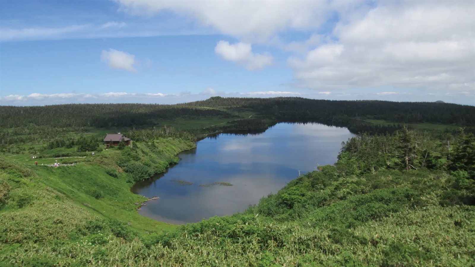 原生林と湿原に囲まれた八幡平最大の火口湖・八幡沼と、ほとりに建つ陵雲荘