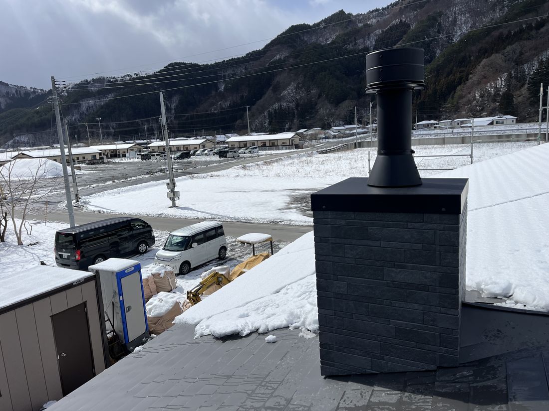 雪景色の中に立つ角トップと煙突（岩手県山田町）