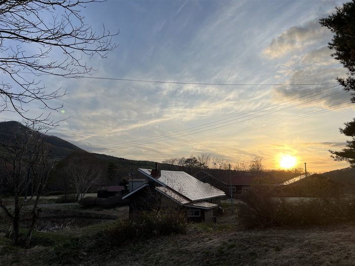 夕暮れの薪小屋。屋根のある屋外で薪を乾かし保管する