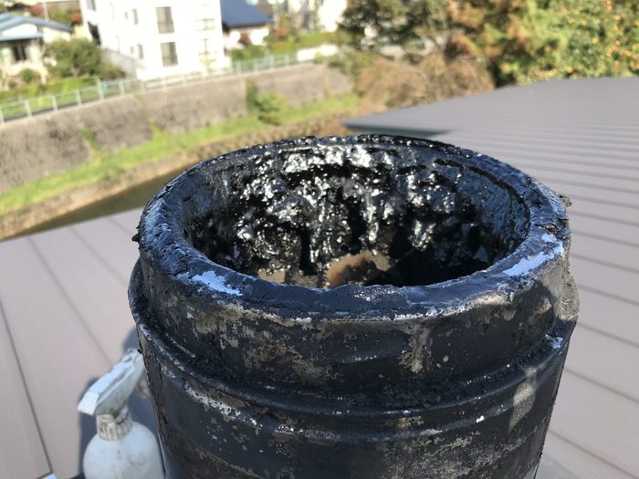 掃除前:タールで真っ黒になった煙突トップ