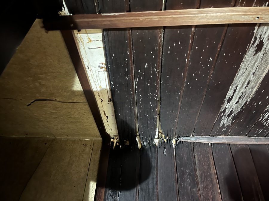 黒ずんで板の端が細かく裂けた、古いサウナ室の壁